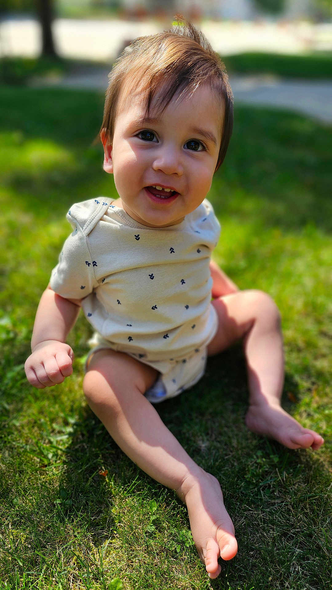 Mickey is registered to the contest to win money with this photo: baby, barefoot, bodypart, clothing, dress, face, finger, grass, hand, happy, head, lawn, outdoors, person, photography, plant, portrait, shorts, sitting, smile