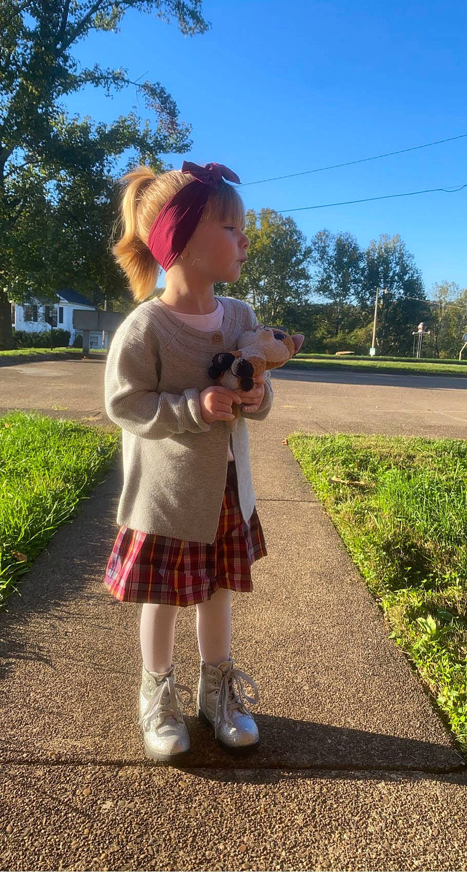Addison is registered to the contest to win money with this photo: asphalt, fawn, fun, grass, hair, happy, leisure, person, plaid, plant, public_space, shoe, sky, standing, street_fashion, sunlight, tartan, toddler, tree, waist
