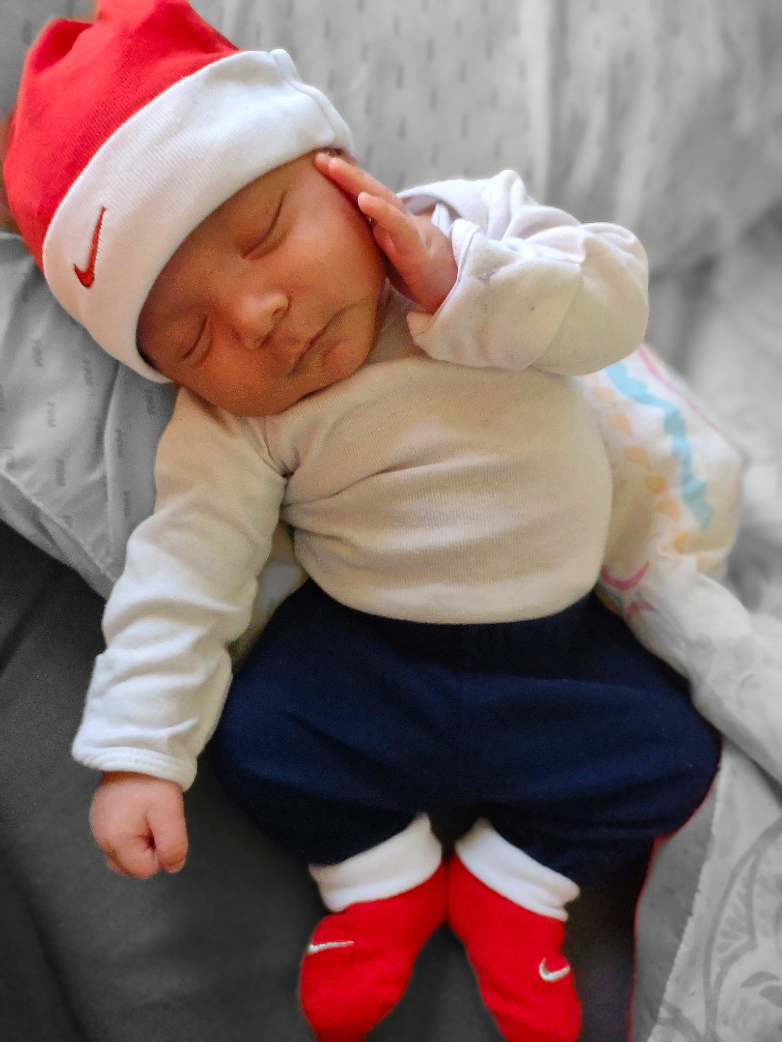 Legend is registered to the contest to win money with this photo: arm, baby, baby_sleeping, baby_toddler_clothing, cap, carmine, child, comfort, finger, flooring, happy, headgear, headwear, human_body, human_leg, knee, person, sitting, sleeve, sock