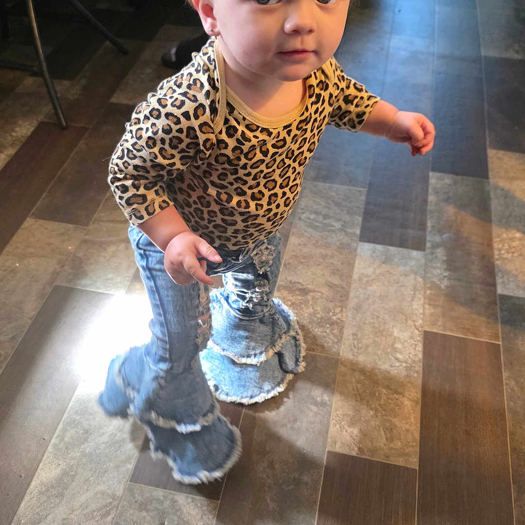 Masie is registered to the contest to win money with this photo: blonde_hair, casual, child, clothing, curious, cute, denim, fashion, floor, hair, indoor, jeans, leopard_print, long_sleeves, looking_up, person, shirt, standing, toddler, young_child