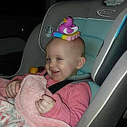 Rebekah joined the competition — help win amazing prizes! toddler, child, car_seat, toy, duck, blanket, pink_clothing, smile, bald_head, indoor, seatbelt, playful, baby_toy, child_seat, car_interior, person, cute, happy, infant, young_child