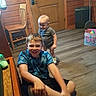 baby, boy, casual_clothing, chair, child, children, door, floor, furniture, happiness, home, indoor, motion_blur, person, playful, sitting, smile, standing, toy_box, wooden_wall
