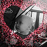baby, stroller, child, heart_shape, overlay, dots, black_and_white, curious, infant, outdoor, window, face, cute, seat, person, side_view, expression, young_child, playful, decoration