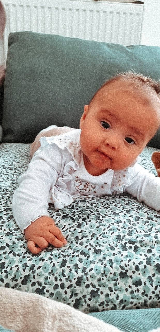 Lyta participe au concours pour gagner de l'argent avec cette photo : baby, baby_toddler_clothing, cheek, child, chin, comfort, facial_expression, floor, flooring, happy, iris, linens, nose, pattern, person, skin, sleeve, smile, textile, toddler