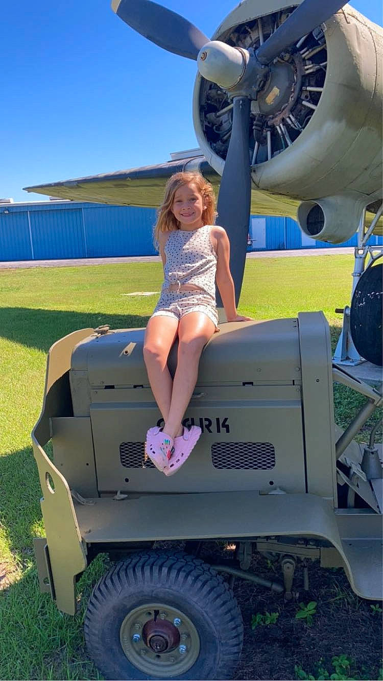 Devyn is registered to the contest to win money with this photo: aircraft, aircraft_engine, airplane, automotive_design, automotive_exterior, automotive_tire, automotive_wheel_system, bumper, fender, fun, hood, joy, leisure, motor_vehicle, person, shorts, sky, smile, tire, travel