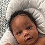 Zyaire is registered to the contest to win money with this photo: baby, infant, face, curly_hair, eyes, smile, skin, cushion, blanket, soft, close_up, child, portrait, indoors, person, newborn, cute, resting, comfort, expression