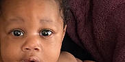 Zyaire joined the competition — help win amazing prizes! baby, infant, face, eyes, skin, expression, curly_hair, blanket, arm, hand, portrait, closeup, child, person, indoors, candid, cute, young, newborn, warm