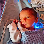 Ayden participe au concours pour gagner de l'argent avec cette photo : newborn, baby, sleeping, blanket, knitwear, infant, swaddled, cozy, cute, face, hand, soft, indoors, resting, peaceful, child, portrait, warm_light, blue_light, fabric