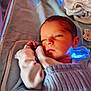 newborn, baby, sleeping, blanket, knitwear, infant, swaddled, cozy, cute, face, hand, soft, indoors, resting, peaceful, child, portrait, warm_light, blue_light, fabric