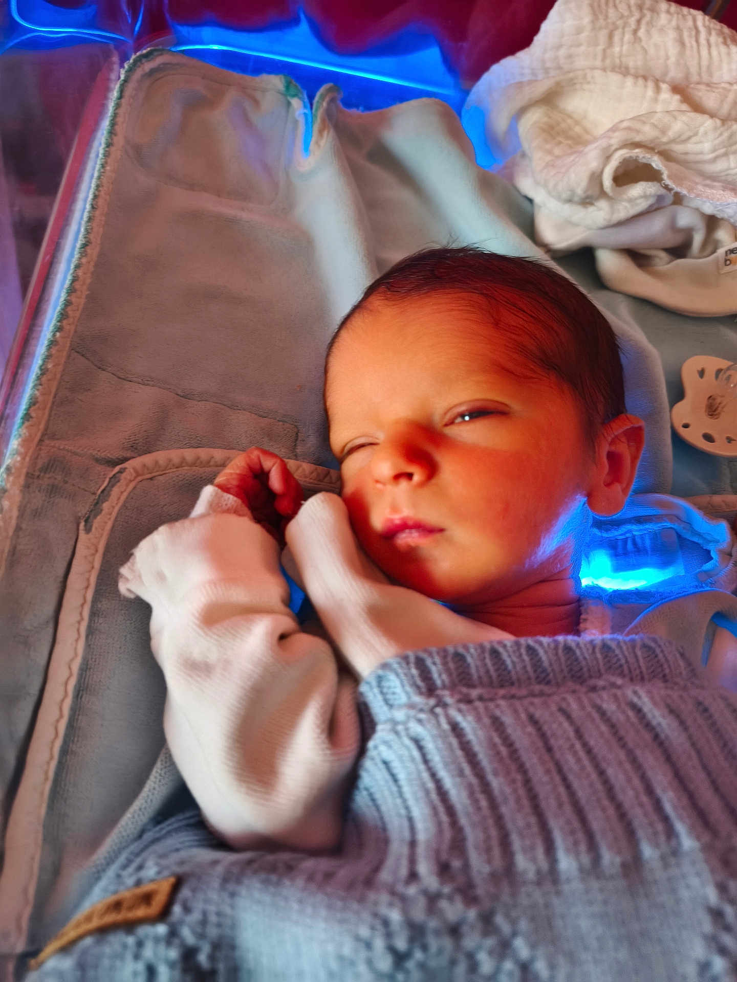 Ayden participe au concours pour gagner de l'argent avec cette photo : newborn, baby, sleeping, blanket, knitwear, infant, swaddled, cozy, cute, face, hand, soft, indoors, resting, peaceful, child, portrait, warm_light, blue_light, fabric