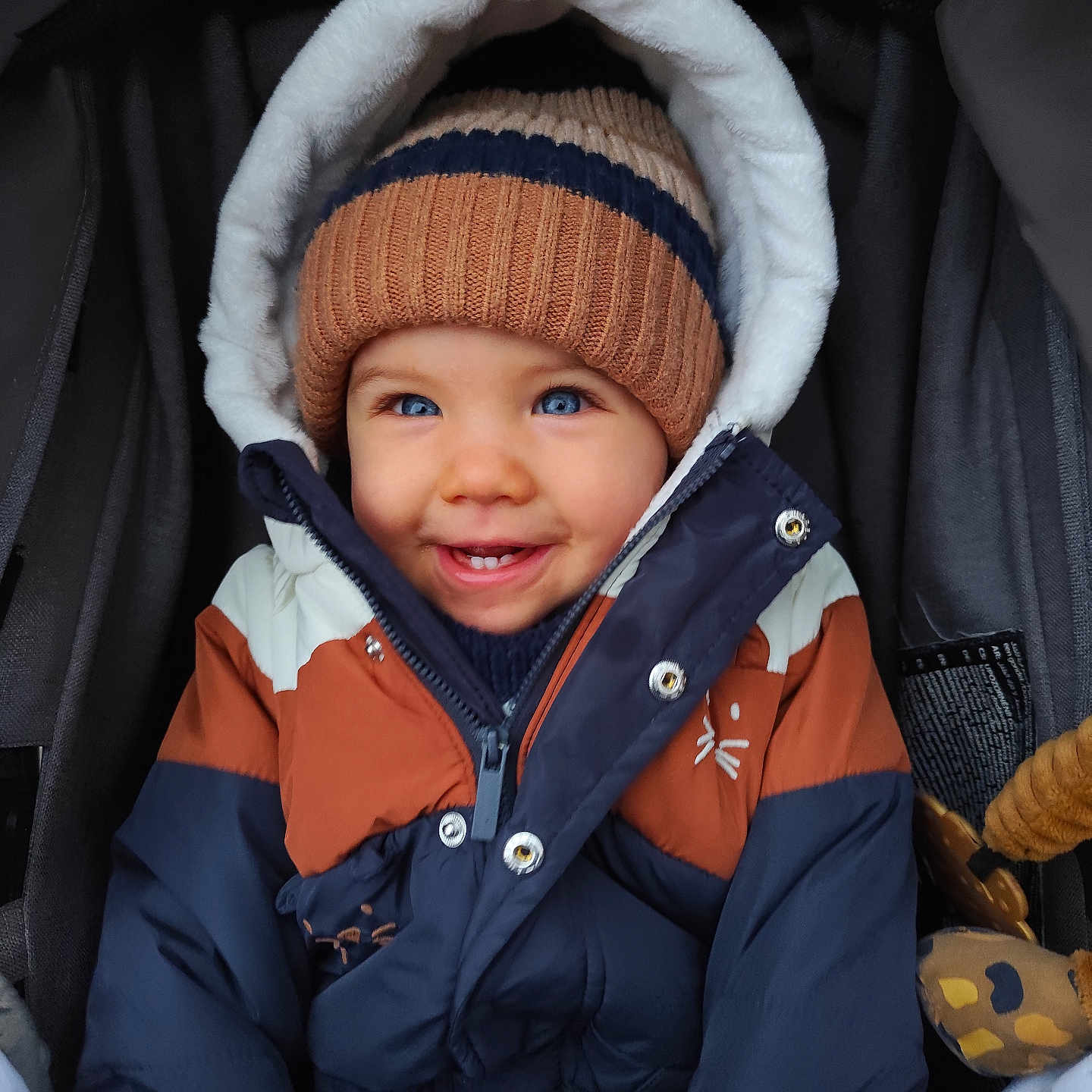 Gabriel a rejoint le concours — aidez-le/la à gagner de superbes lots ! baby, baby_toy, blue_eyes, child, cold_weather, cozy, cute, cute_expression, face, happy, infant, knit_hat, outdoor_clothing, portrait, seat_belt, smile, stroller, toddler, warm_clothes, winter_jacket