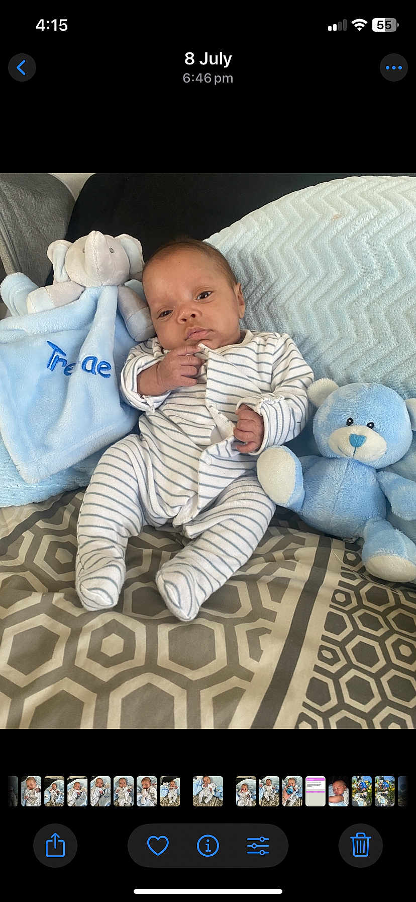 Trenae is registered to the contest to win money with this photo: baby, infant, striped_onesie, plush_elephant, blue_teddy_bear, blanket, pillow, patterned_bedspread, indoor, child, cute, soft_toys, seated, portrait, newborn, cozy, comfort, resting, small_hands, striped_clothing