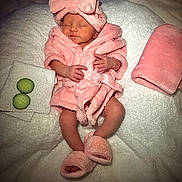 Mila joined the competition — help win amazing prizes! baby, infant, pink_robe, headband, bow, slippers, sleeping, cucumber_slices, towel, blanket, soft_texture, cute, newborn, relaxation, spa_theme, portrait, cozy, resting, indoors, child