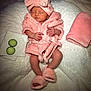 baby, infant, pink_robe, headband, bow, slippers, sleeping, cucumber_slices, towel, blanket, soft_texture, cute, newborn, relaxation, spa_theme, portrait, cozy, resting, indoors, child