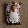 newborn, baby, swaddled, crate, wooden_floor, pink_blanket, headband, sleeping, indoors, infant, wrapped, cute, soft_texture, peaceful, portrait, resting, wood, decor, baby_girl, cozy