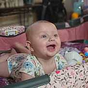 Holly is registered to the contest to win money with this photo: baby, infant, playpen, smiling, happy, tummy_time, toys, colorful, blanket, child, indoor, cute, young, person, pattern, fabric, soft, play, joyful, expression