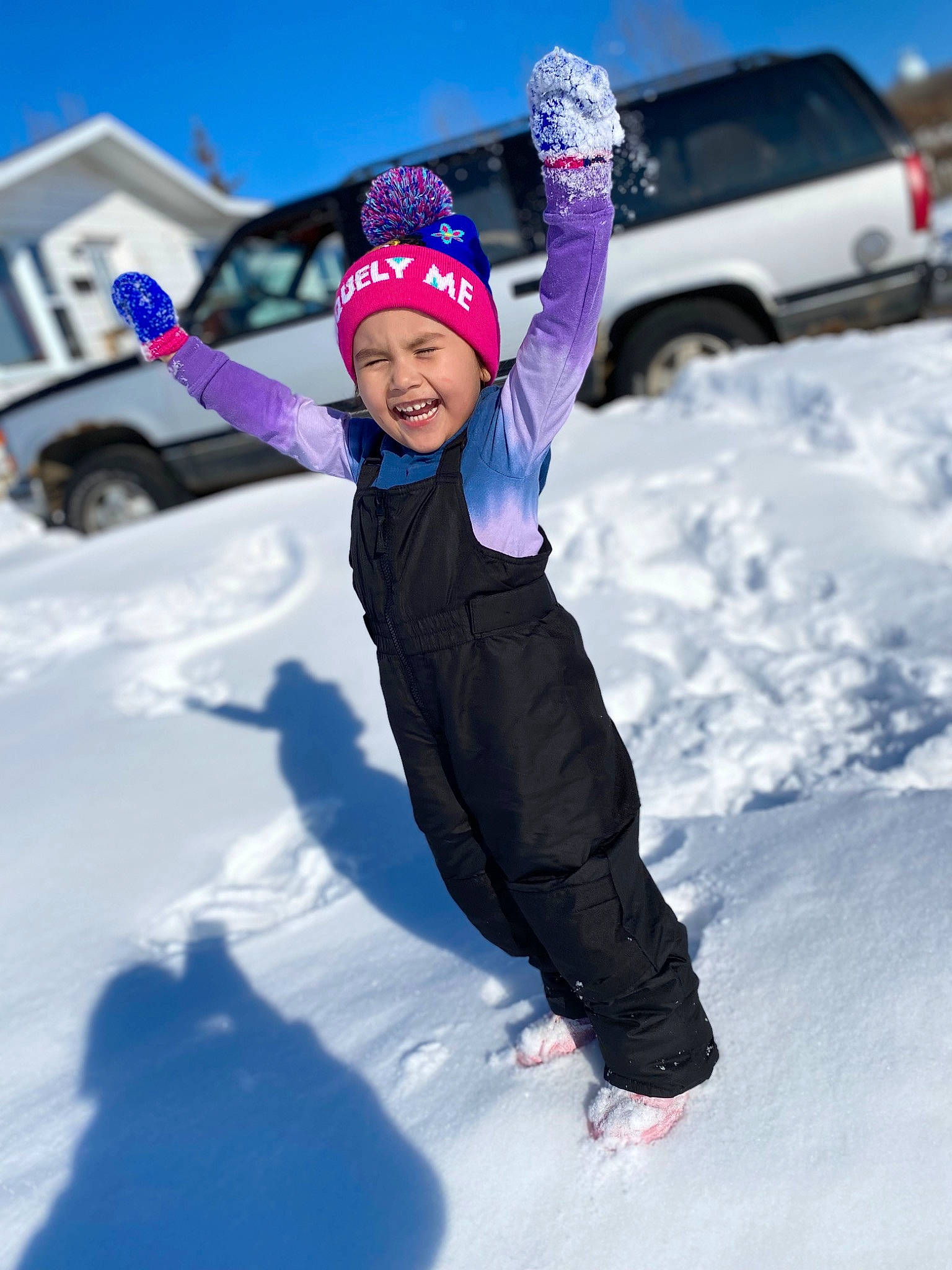 Aarilynn is registered to the contest to win money with this photo: automotive_tire, car, electric_blue, event, freezing, fun, glove, happy, headwear, jacket, leisure, person, recreation, sky, smile, snow, tire, toddler, tree, vehicle