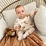 Liam participe au concours pour gagner de l'argent avec cette photo : baby, pacifier, blanket, plush_toy, giraffe, chair, wicker, cozy, child, clothing, socks, cute, infant, indoor, soft_texture, pattern, person, seated, comfortable, portrait