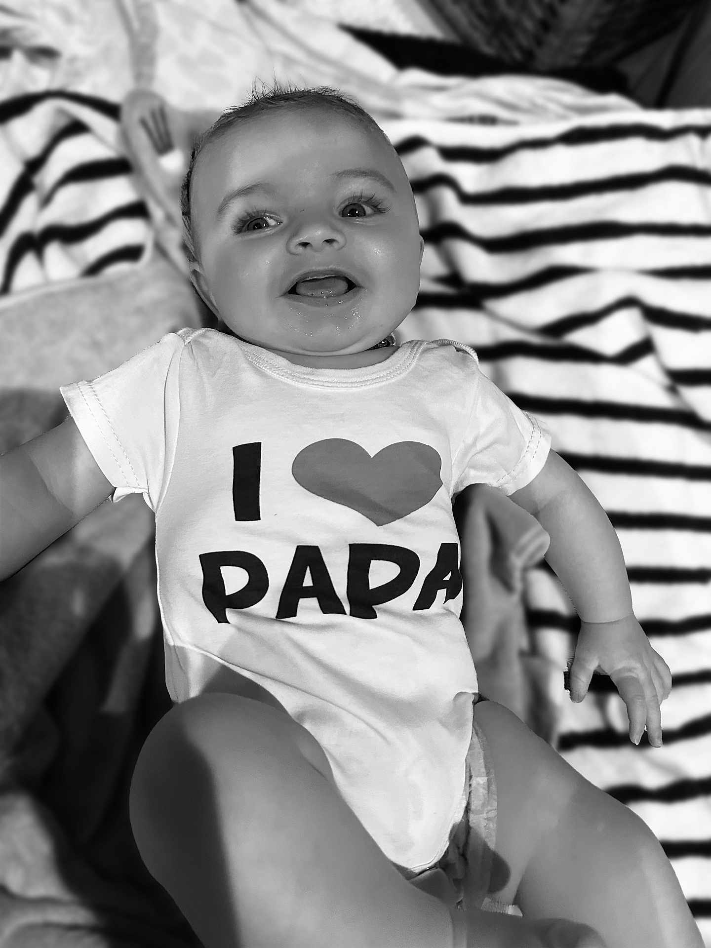 Sohan a rejoint le concours — aidez-le/la à gagner de superbes lots ! baby, infant, smiling, onesie, clothing, text, heart, blanket, striped, happy, face, child, cute, portrait, lying_down, young, human, skin, expression, joyful