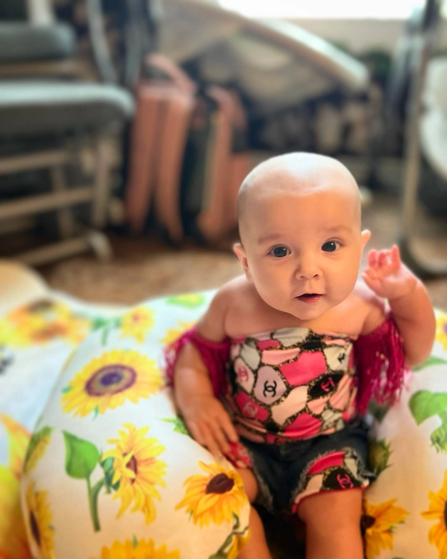 Bonnie is registered to the contest to win money with this photo: abdomen, baby, baby_toddler_clothing, cheek, child, comfort, eye, face, finger, fun, happy, head, human_leg, pattern, people, person, room, sitting, skin, thigh