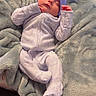 baby, sleeping, blanket, pajamas, headband, purple_bow, infant, cozy, soft_texture, resting, cute, peaceful, child, indoors, carpet, comfort, warm, newborn, clothing, portrait