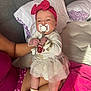 baby, pacifier, headband, bow, tutu, onesie, socks, bracelets, person, bed, pillow, blanket, pink, white, holding, infant, cute, sleepwear, indoor, soft_lighting