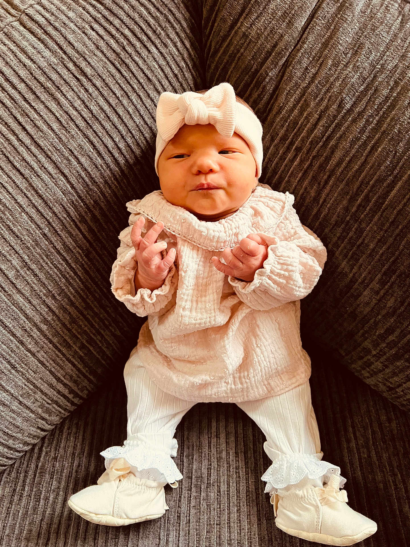 Zélie participe au concours pour gagner de l'argent avec cette photo : baby, infant, couch, clothing, headband, booties, white_clothes, frills, texture, soft_lighting, indoors, portrait, cute, small_hands, seated, comfortable, fashion, child, newborn, cozy