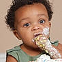 Cyrus is registered to the contest to win money with this photo: toddler, child, cake, frosting, messy, face, hand, green_clothing, curly_hair, portrait, eating, food, indoor, closeup, cream, celebration, birthday, caucasian_skin, happy, cute