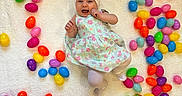 Braelynn is registered to the contest to win money with this photo: baby, infant, child, easter_eggs, colorful, heart_shape, blanket, headband, floral_dress, smiling, lying_down, playful, indoors, soft_texture, cute, festive, celebration, pastel_colors, toy, happy