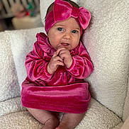 Braelynn is registered to the contest to win money with this photo: baby, infant, pink_dress, headband, bow, velvet, sitting, chair, white_fabric, cozy, cute, portrait, child, indoors, soft_texture, feet, hands, looking_at_camera, young_child, smiling