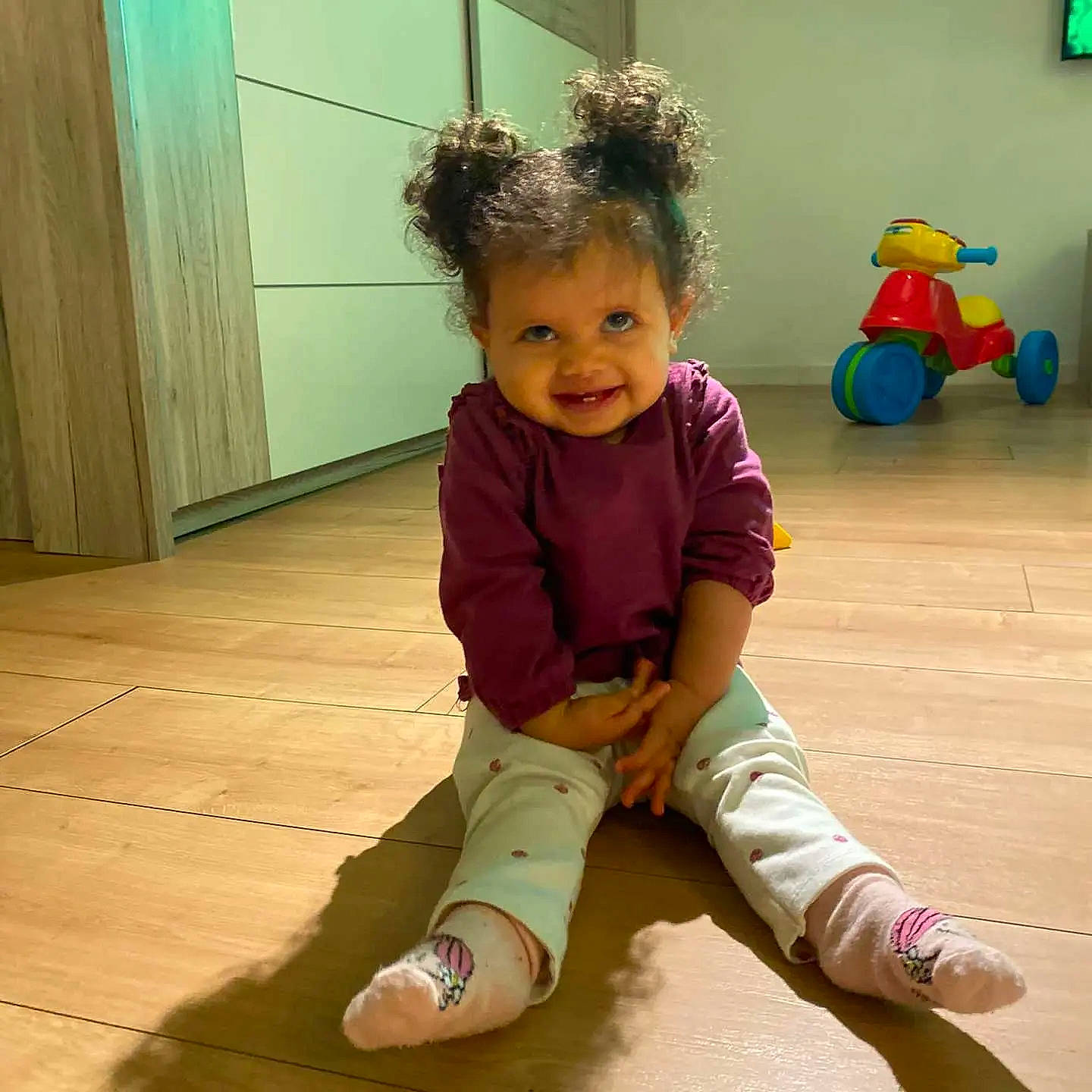 Jenalia participe au concours pour gagner de l'argent avec cette photo : baby_toddler_clothing, facial_expression, floor, flooring, fun, green, happy, hardwood, human_body, joy, knee, leg, person, skin, sleeve, smile, standing, thigh, toddler, toy