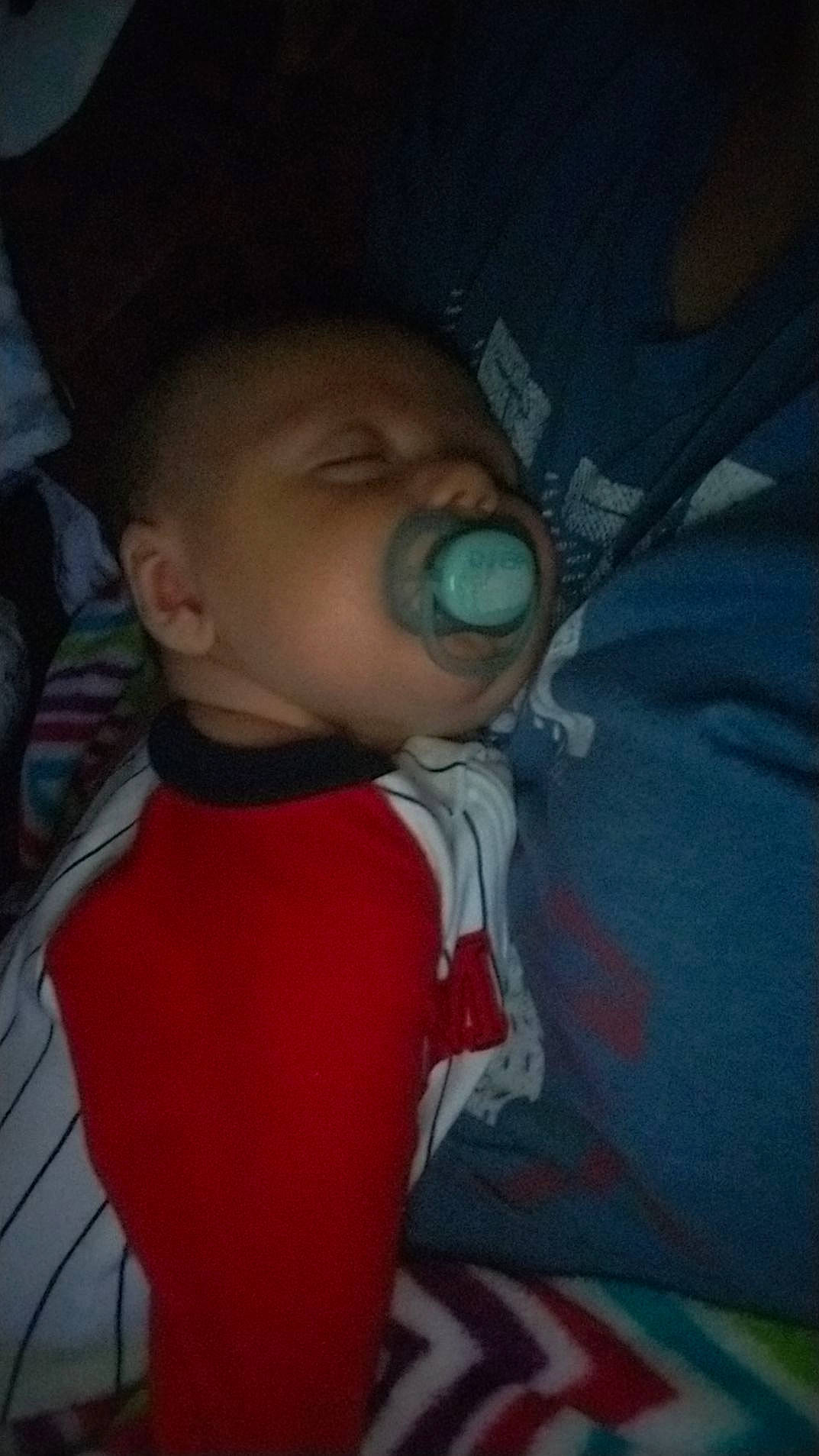 Forrest is registered to the contest to win money with this photo: baby, baby_products, baby_toddler_clothing, carmine, cheek, child, comfort, darkness, eye, fun, iris, linens, lip, mouth, nose, person, room, sitting, skin, t_shirt