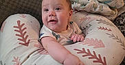 Koa is registered to the contest to win money with this photo: baby, infant, pillow, blanket, couch, indoor, smiling, child, person, furniture, pattern, comfort, reaching, clothing, face, head, arm, foot, home, cozy