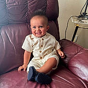 Mark joined the competition — help win amazing prizes! baby, child, smile, leather_chair, maroon, cream_outfit, wooden_buttons, navy_shoes, indoor, happy, person, furniture, seat, cute, infant, sitting, human, portrait, candid, home