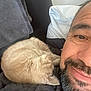 Nala participe au concours pour gagner de l'argent avec cette photo : cat, man, smile, beard, blanket, pillow, face, fur, resting, cozy, indoors, relaxation, pet, companion, closeup, comfort, nap, feline, human, friendship