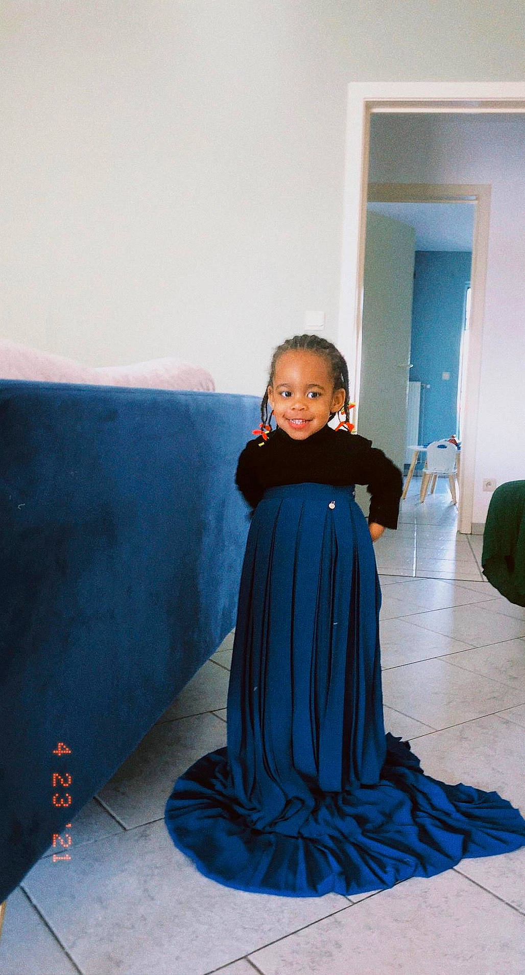 Clara participe au concours pour gagner de l'argent avec cette photo : azure, child, day_dress, door, dress, electric_blue, face, fashion_design, floor, flooring, formal_wear, joy, magenta, one_piece_garment, pattern, person, purple, sitting, sleeve, smile