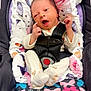 baby, infant, car_seat, blanket, floral_pattern, pajamas, face, hands, feet, butterfly_pattern, seatbelt, child, cute, newborn, expression, comfort, soft, indoor, portrait, wearing