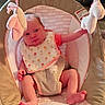 baby, infant, child, portrait, bouncer, baby_seat, pink, floral_bib, plush_toys, hanging_toys, sitting, indoors, home, cozy, face, eyes_open, legs, feet, photography, safe