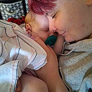 Serenity is registered to the contest to win money with this photo: adult, affection, baby, bed, blanket, closeup, cuddle, face, family, gray_shirt, indoor, newborn, pacifier, parent, photography, pink_hair, portrait, sleeping, striped_blanket, tender_moment