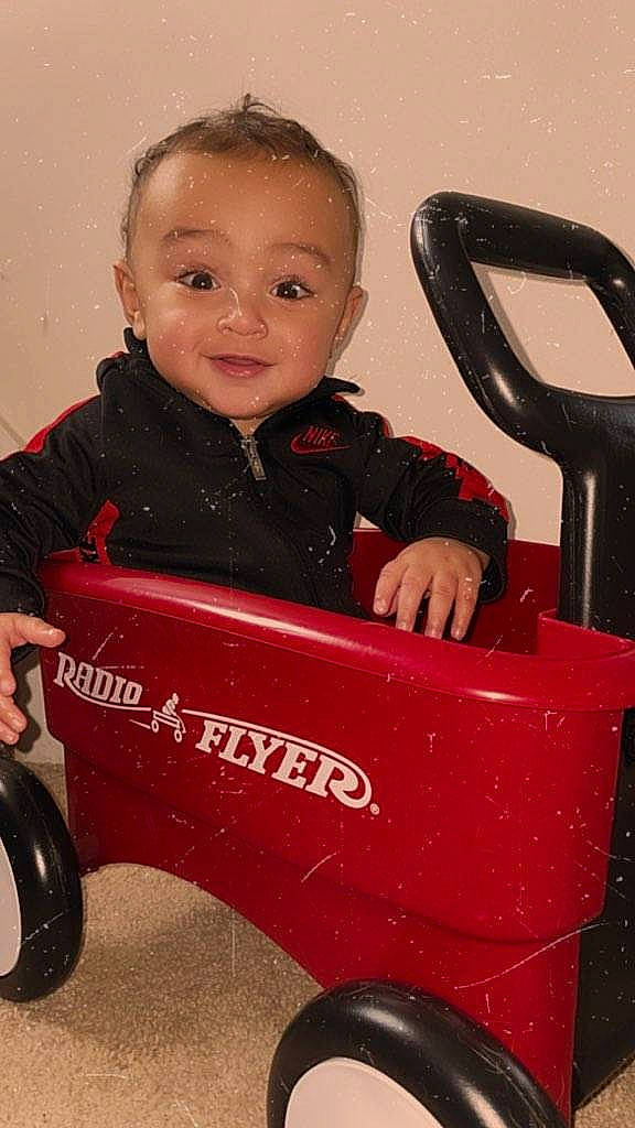 Julius is registered to the contest to win money with this photo: baby, baby_laughing, baby_playing_with_toys, baby_toddler_clothing, baby_toys, cheek, child, child_model, joy, laugh, organ, person, plastic, play, red, riding_toy, rolling, sitting, toddler, toy