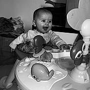 Liyah participe au concours pour gagner de l'argent avec cette photo : activity_center, baby, black_and_white, box, candid, child, clothing, expression, face, floor, furniture, happy, indoor, infant, person, play, seat, smiling, toy, young_child