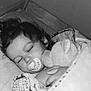 bed, blanket, child, comfort, cozy, curly_hair, cute, indoors, monochrome, nap, pacifier, peaceful, plush_toy, portrait, quiet, resting, sleeping, soft, wrapped, young_child