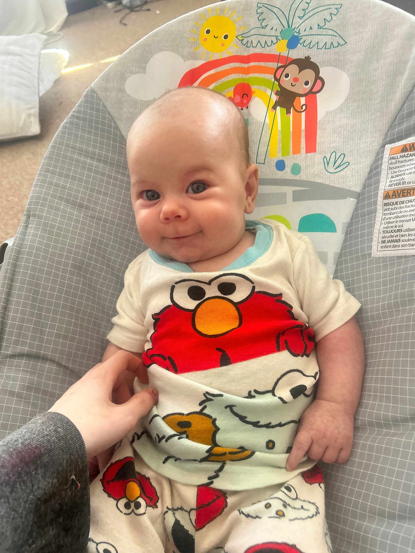 Avery is registered to the contest to win money with this photo: baby, infant, smile, pajamas, elmo, hand, bouncer, cartoon, child, cute, indoor, person, clothing, colorful, seat, comfort, playful, expression, young, happy