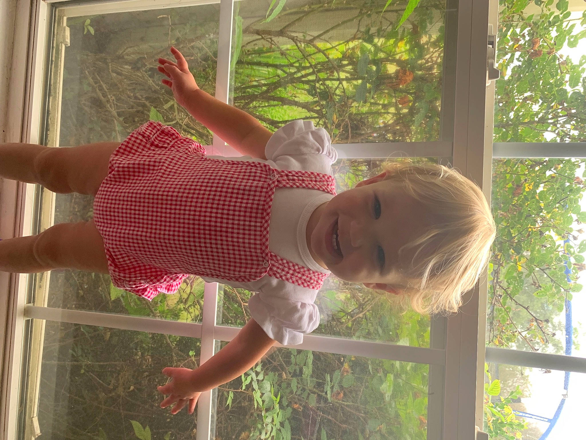 Emma is registered to the contest to win money with this photo: baby, baby_toddler_clothing, botany, child, fun, grass, happy, human_leg, joy, leisure, person, photograph, plant, red, smile, snapshot, summer, thigh, toddler, tree