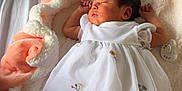 Anaïa a rejoint le concours — aidez-le/la à gagner de superbes lots ! newborn, baby, sleeping, dress, floral_embroidery, blanket, pacifier, booties, bear_design, soft_texture, cozy, indoors, infant, cute, peaceful, sleep, child, laying_down, fabric, comfort