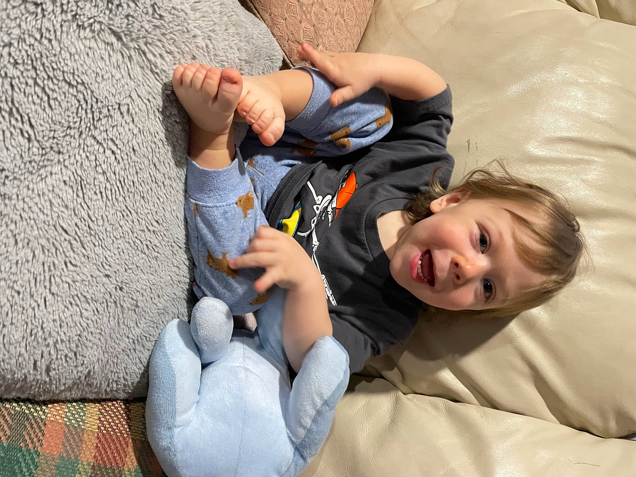 Jace is registered to the contest to win money with this photo: arm, child, comfort, elbow, foot, fun, gesture, grass, happy, human_leg, joint, knee, leisure, linens, person, sitting, smile, t_shirt, thigh, thumb