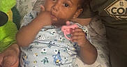 Evangeline joined the competition — help win amazing prizes! toddler, child, baby, pacifier, thumb_sucking, plush_toy, bedding, blanket, person, couch, clothing, patterned_fabric, curly_hair, earrings, indoor, relaxed, comfort, hand, adult, casual_wear