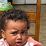 Evangeline joined the competition — help win amazing prizes! toddler, child, curly_hair, wooden_chair, indoor, expression, face, person, clothing, earrings, tile_floor, background, furniture, pink_shirt, closeup, portrait, young_child, confused_expression, home, candid