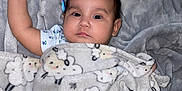 Avellana is registered to the contest to win money with this photo: baby, blanket, sheep_pattern, carpet, soft_texture, child, infant, raised_arm, lying_down, cozy, indoors, cute, sleepwear, sleeping_area, resting, portrait, young_child, warm, comfort, peaceful