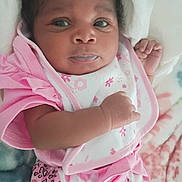Aviana is registered to the contest to win money with this photo: baby, infant, pink_clothing, blanket, face, cute, portrait, newborn, lying_down, child, soft_toys, patterned_clothing, hand, expression, indoors, close_up, skin, person, resting, young_child